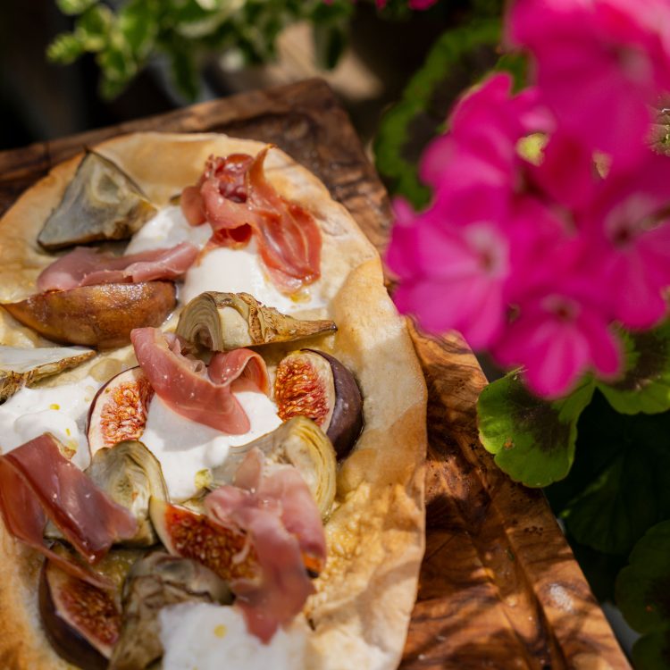 A7R07813 - 2023 - Gees Restaurant & Bar - Oxford - High Res - Artichoke Fig Prosciutto Pizzetta Sunlight Green Flowers (Press Web)